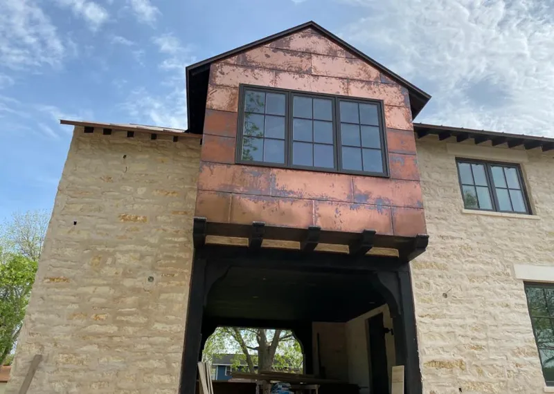Copper metal panel facade on a stone building for Roof Repair in West Richland